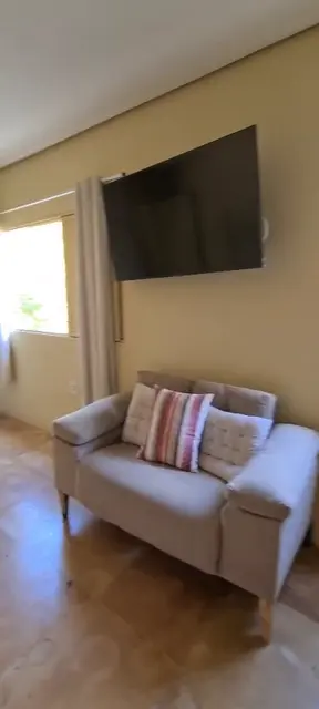 Sala com TV e sofá claro — Casa Bambu, Sítio Bambu Rede