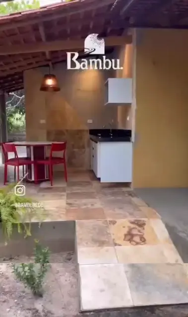 Cozinha externa com mesa vermelha — Chalé Cajueiro, Sítio Bambu Rede